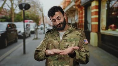 Ordu üniformalı İspanyol bir adam. Yoğun bir sokakta sakallı jestler yapıyor. Para kavramını anlatıyor..