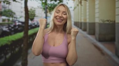 Kadın, yumuşak gün ışığı altında heybetli yapı sütunları arasında kaldırım taşı caddesinde el sıkışıyor; güven.