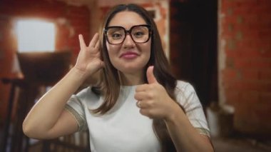 Kadın inşaat sahasında çıplak elle onay veriyor; iyimserlik takım çalışması verimliliği.