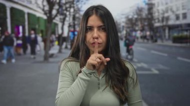 Açık bir şehir caddesinde sessiz hareketler yapan İspanyol kadın, şehir yaşamında huzur ve sükuneti vurguluyor..