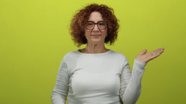 Beyaz kazaklı, orta yaşlı bir kadın. Parmaksız, sarı arka planda..