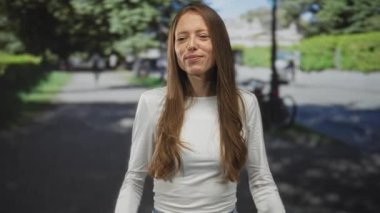 Park halindeki bisikletle kıt kanaat geçinen, gülümseyen ve öne doğru eğilen kadın sanki bağırıyormuş gibi; neşeli bir duyuru.