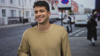 Bir adam kalabalık bir sokakta el kaldırırken genç bir İspanyol adam açık hava kentsel anının tadını çıkarıyor..