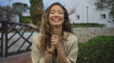 Açık havada gülümseyen, genç ve kaygısız bir kadın, güneşli bir açık havada mutluluğu ifade ediyor, gündelik ve neşeli..