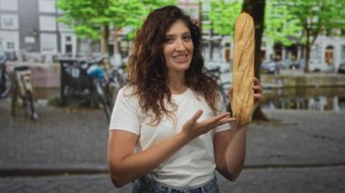 Amsterdam 'da bir kaldırım taşı caddesinde elinde baget tutan ve onu işaret eden bir kadın, neşeli bir merak..
