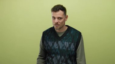 İzole edilmiş sarı arka planda duran bir adam, orta çekim formatında düşünceli bir ifadeye sahip genç bir yetişkini görüntüler..