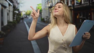 Genç kadın elinde bir pano tutarken ve gülümserken parmağını yukarı kaldırıyor; özgüven liderliği özgüveni.