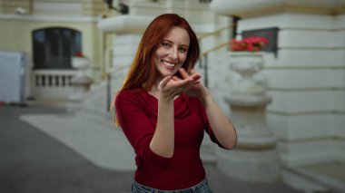 Gülümseyen ve para kazanan bir kadın, şehir caddesinde açık havada, günlük kıyafetlere neşe ve güven gösterisi yapıyor..