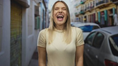 Arka planda arabalar olan bir caddede bağıran kadın, gün boyunca şehir ortamında ayakta dururken duygularını ifade ediyor..
