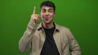 Adam yeşil bir stüdyoda genç bir İspanyol 'u düşünürken çenesine dokunuyor..