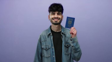 Elinde mor arka planda seyahat belgesi gösteren kot ceketli İsrail pasaportu tutan bir adam..