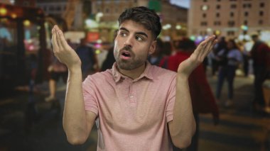 Genç İspanyol adam, yoğun şehir caddesinde geceleri el ve avuç içlerini kaldırıyor. Hayal kırıklığı..