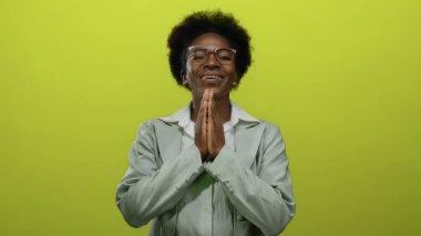 İzole edilmiş sarı arka planda gülümseyen kadın, huzuru, rahatlığı, maneviyatı, pozitifliği, farkındalığı, gençlik sükunetini ve odaklanmayı ön plana çıkarıyor..