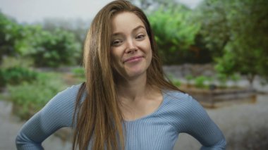 Kadın el sallama hareketi eğimli kafa ve ormanlık alanda rahat omuzlar; neşe neşe kahkahaları.