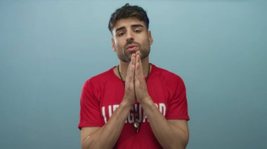 Kırmızı tişörtlü, gümüş düdüklü genç İspanyol cankurtaran mavi stüdyoda el ele tutuşuyor..