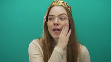 Altın taç takan genç prenses kıt kanaat geçiniyor yeşil stüdyo ortamında fısıldıyor..