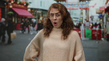 Şehir caddesinde şaşırdığını ifade eden kadın canlı şehir ortamında etkin yayalar, açık hava kentsel yaşam dinamikleri ve çok kültürlü çeşitlilik sergiliyor..