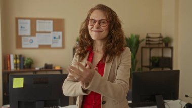 Modern ofis ortamında bilgisayar ve çizelgelerle çevrili kırmızı gömlek ve gözlük takan, motivasyon ve iş yerinde başarı taşıyan kadınlar..