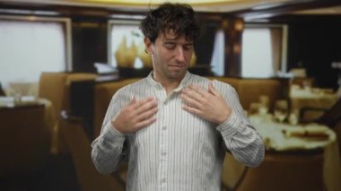 Zarif restoranda şık bir gömlek ayarlayan adam yumuşak ışıklandırma ve şık dekor ile İspanyol görünümlü yakışıklı ve rahat bir atmosfer sergiliyor..