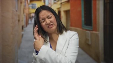 Beyaz ceketli kadın rengarenk şehir sokaklarında el ele tutuşmaktan rahatsız olduğunu ifade ediyor. Duygularını ve şehir yaşamını yansıtıyor..