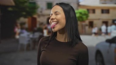 Canlı bir sokakta, arka planda açık gökyüzünün altında bulanık binalar ve arabalarla neşeli bir şekilde gülümseyen bir kadın..