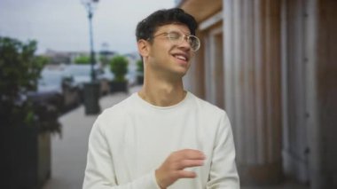 Gündüz vakti kalabalık bir şehir caddesinde konuşan genç bir İspanyol el hareketi ve anlamlı yüz ile iletişim ifadesi belirsizliği.