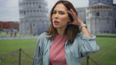 Güneşli bir günde güneşli bir günde güneşli bir günde İtalya 'da sidik kulesinin yanında dinleyen ve ünlü bir turist manzarasına karşı meraklı bir ifade sergileyen bir kadın..