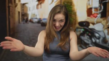 Genç Kafkas kadın neşeli bir şekilde el uzattı buraya bir kaldırım taşı sokakta jest; sıcak dostça karşılama daveti.