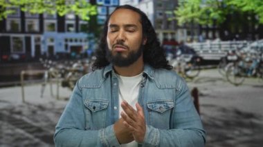 Elleri sımsıkı bağlı ve dar kot ceketli bir adam sokakta bisiklet ve kanalı olan; hüsran..