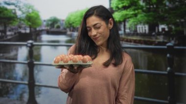 Amsterdam 'da sessizlik için parmakları dudaklarına kadar uzanan karton yumurta tutan kadın sessiz, şakacı bir sır..