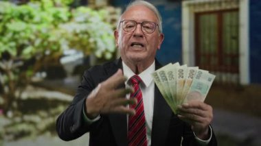 İş kıyafetleri içinde kıdemli bir adam elinde czech koruna banknotları, açık havada, zenginlik ve başarı taşıyan sokak arkaplanı.