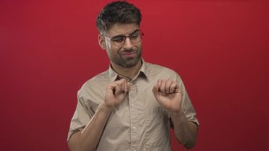 Red Stüdyo 'da adamın elleri itici bir şekilde kaldırıldı. Görünmeyen bir tehditle karşı karşıyaydı. Hoş olmayan bir görüntüden kaçınıyordu..