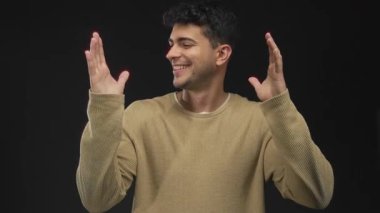 Erkekler el ele tutuşup, onları arka plana doğru kaldırıyor. Genç İspanyol erkek gülümsüyor ve siyah uzayı çerçeveliyor..