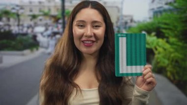 İspanyol kadın bardakları el ele ve bağırıyor şehir sokaklarında yeşil plaka tutarak; heyecan.