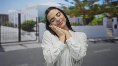 Güneşli bir sokakta mutlu bir şekilde hayal kuran kadın huzurlu bir şehir ortamında gözleri kapalı sükuneti temsil ediyor..