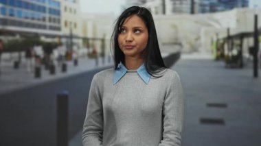 Şehir caddesinde el çırpan kadın, genç ve şık görünümlü Latin kültürü ve şehir ortamının yer aldığı açık hava ifadesini yakalıyor..