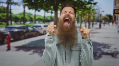 Uzun sakallı ve ağzı açık yumruklarını sıkan ve şehir sokaklarında bağıran bir adam. Heyecan..