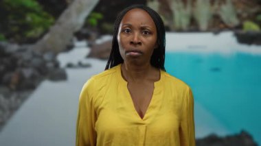 Havuz kenarındaki sarı tişörtlü kadın sakin bir açık hava ortamında kararlı bir şekilde bir odak ve yoğunluk anı yakalıyor..