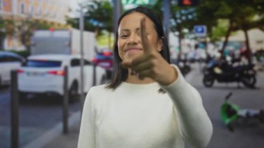 Gündüz bulanık trafik geçmişiyle güvenle gülümseyen bir kadın moda ve kendinden emin bir jest sergiliyor..