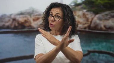 Orta yaşlı İspanyol kadın, Rocky Sahili 'nde reddedilme jesti olarak kollarını kavuşturuyor. İnatçılığı reddediyor..