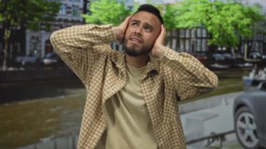 Amsterdam 'da bir caddede, bir kanalda el ele tutuşan adam rahatsızlığını dile getiriyor; kentsel gürültü sıkıntısı.