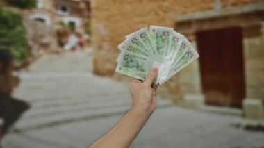 Şehir ortamında, mimari ve kentsel çevreyi aydınlatan bulanık bir arka planla yakalanmış, açık havada tek başına duran dolar..