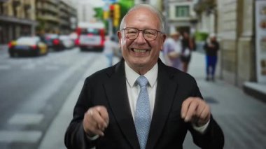 Kıdemli işadamı canlı bir şehir caddesinde gülümsüyor. Trafik ve yayalar bulanık. Güven ve profesyonellik gösteriyor..
