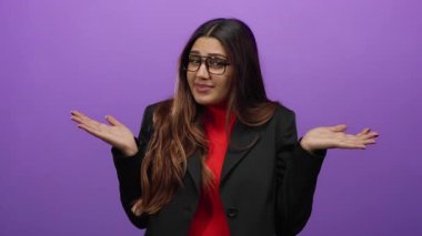 Şaşkın bir ifadeyle hayat dolu mor arka plana karşı omuz silken bir kadın.