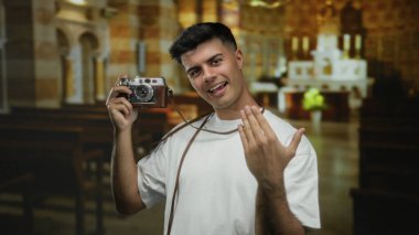 Beyaz gömlekli İspanyol bir adam kilisenin içinde klasik kamerayla jest yapıyor ve davetkar bir ortam yaratıyor..