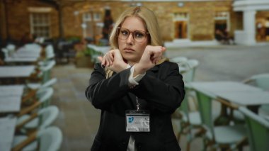 Kadınlar, restoranda elleri boş, masaları boş, iş kıyafetleri içinde gözlük takan ve kimlik kartı takan kadınlara el kol hareketi yapmazlar.