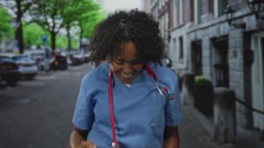 Mavi önlüklü kadın doktor sokakta kırmızı steteskop tutan yumruklarını kaldırdı; kariyer kilometre taşı ve iyimserlik.