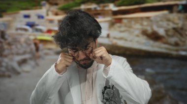 Laboratuvar önlüklü, sakallı genç bir İspanyol manzaralı sahilde ağlayarak mizah ve bilimi eşsiz bir deniz kenarında harmanlıyor..