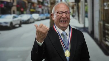 Takım elbiseli, gözlüklü, gülümseyen ve parmağıyla boynuna madalya takmış, şehir geçmişi bulanık bir adam..