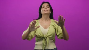 Gözleri kapalı genç İspanyol kadın, elleri mor stüdyoda olan jestleri durdurun, dikkatli olun..